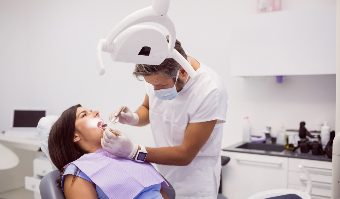 dentist-examining-female-patient-teeth